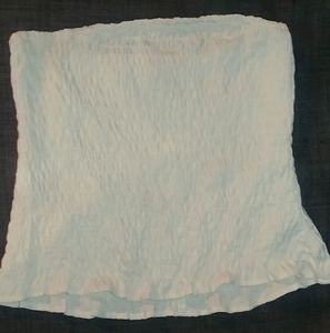 Strapless crop top with lettuce style flow at end.